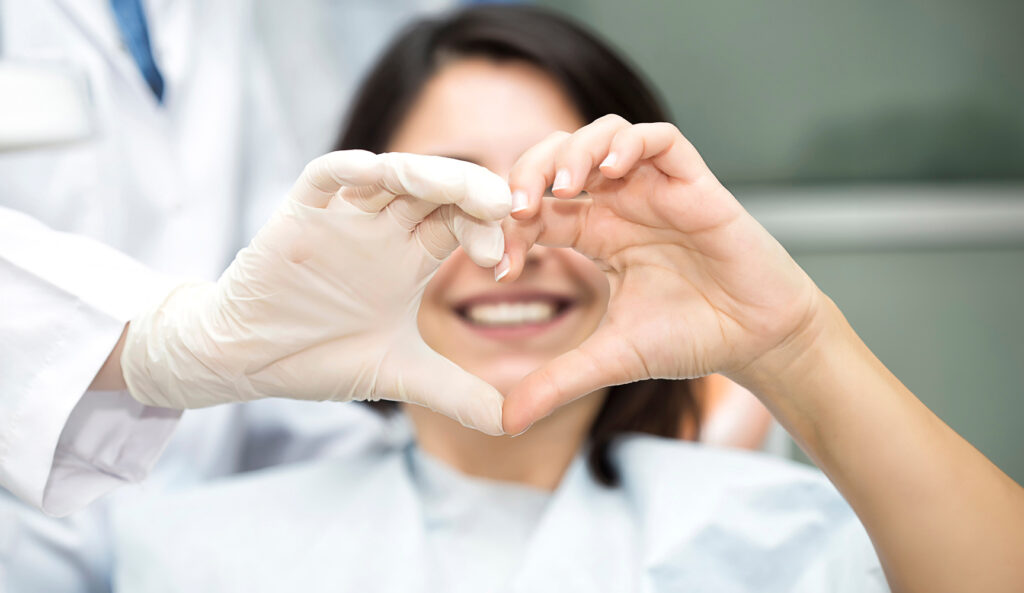 Doctor And Patient Forming A Heart With Their Hands