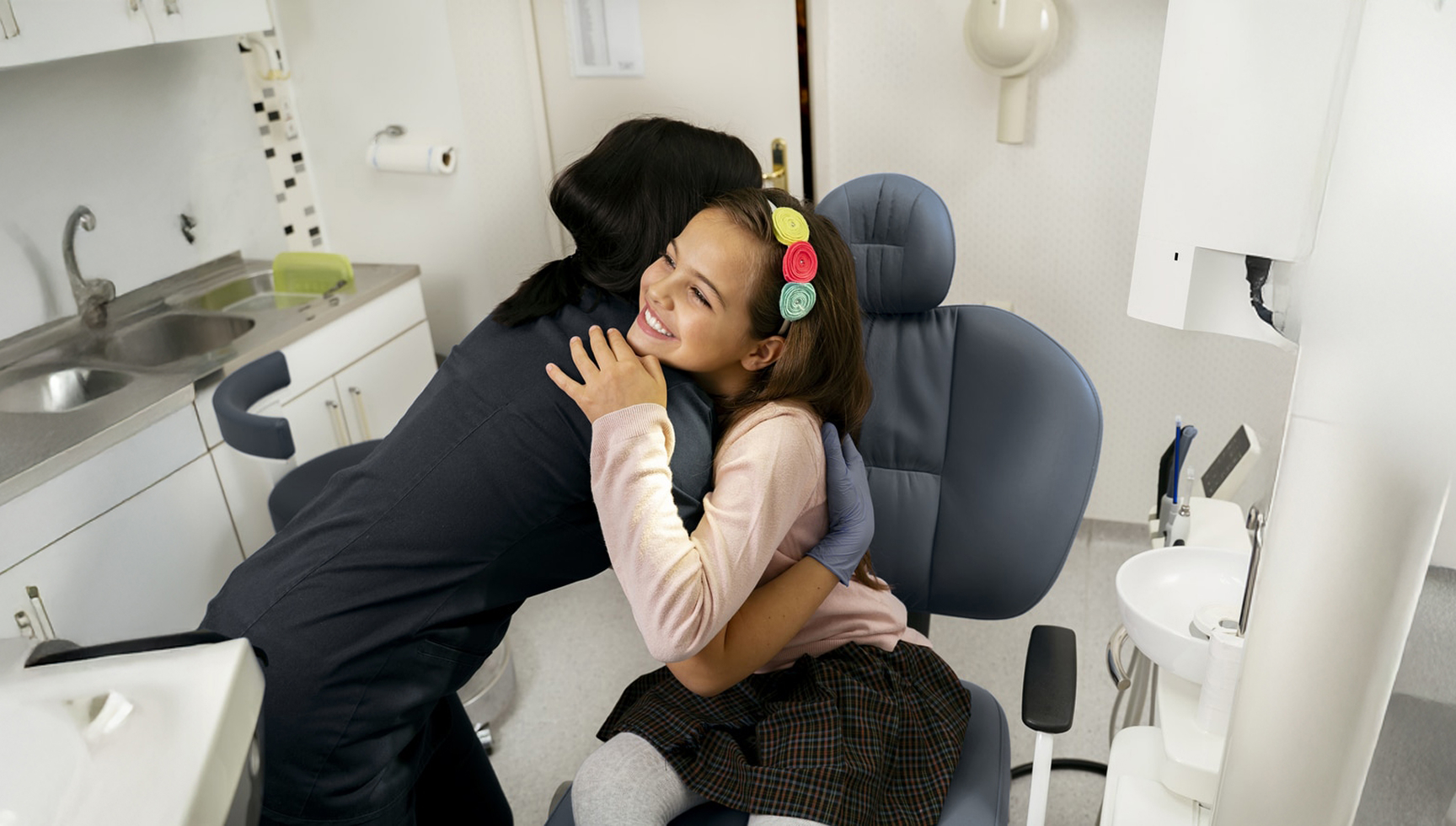 Happy Girl Patient Being Huged By A Nurse In Black Scrubs